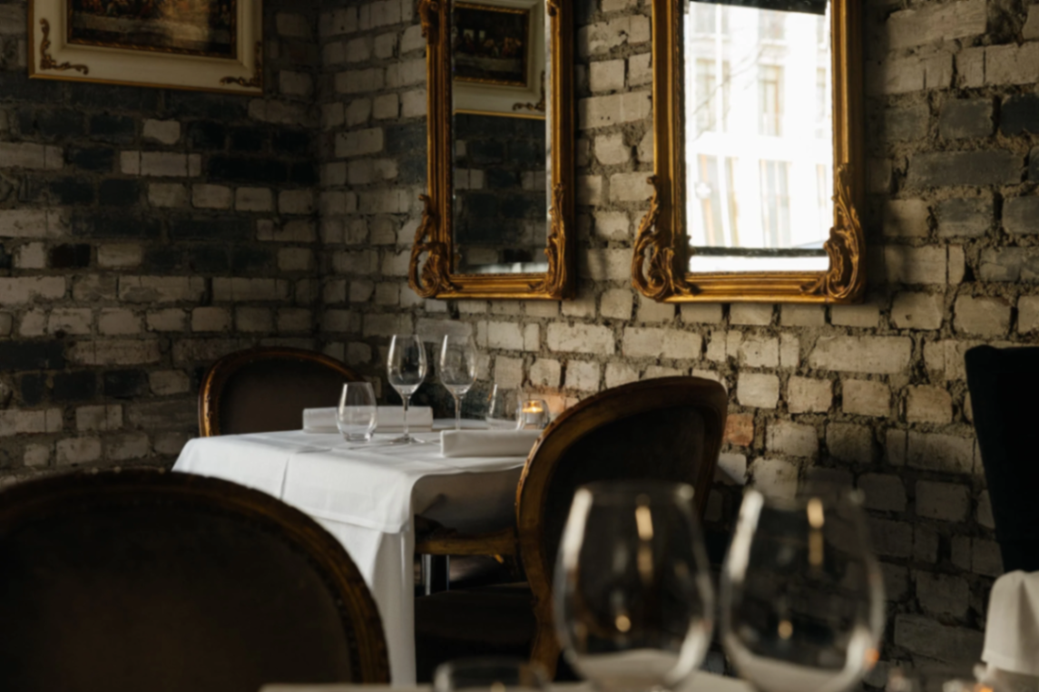 Antika speglar med förgyllda ramar på en tegelvägg i en restaurangmiljö